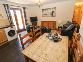 A living room with a dining table and sofa at The Dairy in Penuel near Llanmorlais