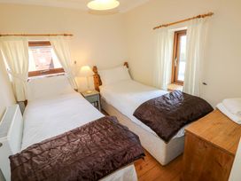 A bedroom with two beds and a window at The Dairy Penuel near Llanmorlais