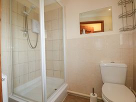 A bathroom with a shower and toilet at The Dairy in Penuel near Llanmorlais