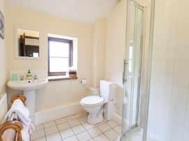 A bathroom with a toilet sink towel rack shower and window at Moonlight Cottage in Coltishall