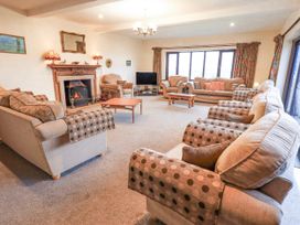 A living room with sofas and a fireplace at Ghyll Bank House in Staveley near Windermere