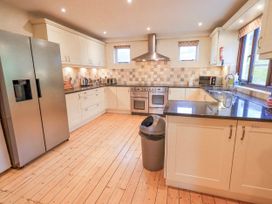 A kitchen with appliances and cabinets at Ghyll Bank House in Staveley near Windermere