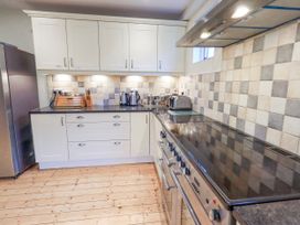 A kitchen with a stove, refrigerator, and countertop at Ghyll Bank House in Staveley near Windermere