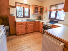 A kitchen with wooden cabinets and a sink at Ghyll Bank House Staveley near Windermere
