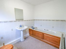 A bathroom with a bath tub and wash basin at Ghyll Bank House Staveley near Windermere