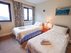 A bedroom with two beds and a nightstand at Ghyll Bank House, Staveley near Windermere