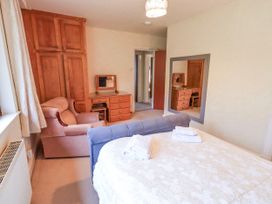 A bedroom with a bed and wardrobe at Ghyll Bank House in Staveley near Windermere