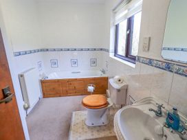 A bathroom with a bathtub, toilet, and sink at Ghyll Bank House Staveley near Windermere
