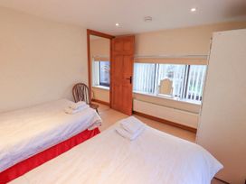 A bedroom with two beds and a window at Ghyll Bank House in Staveley near Windermere