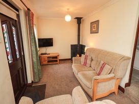 A living room with sofa and television at Ghyll Bank Bungalow Staveley near Windermere
