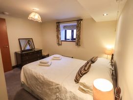 A bedroom with a bed, dresser, and window at Ghyll Bank Bungalow Staveley near Windermere