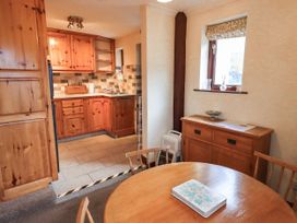 A dining room with wooden furniture at Ghyll Bank Bungalow Staveley near Windermere