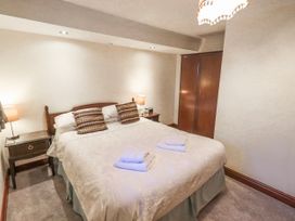 A bedroom with a bed and nightstands at Ghyll Bank Bungalow Staveley near Windermere