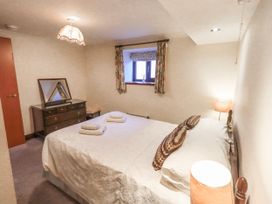 A bedroom with a bed and a dressing table at Ghyll Bank Bungalow Staveley near Windermere