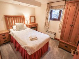 A bedroom with single bed and wooden furniture at Ghyll Bank Bungalow Staveley near Windermere