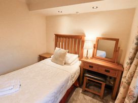 A bedroom with a bed and dresser at Ghyll Bank Bungalow Staveley near Windermere