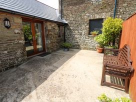 An outdoor area with a bench and planters at The Stall in Penuel near Llanmorlais