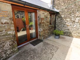 An outdoor area with a wooden door and stone walls at The Stall in Penuel near Llanmorlais