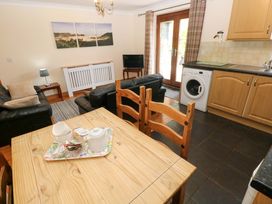 A living room with sofa, table, and television at The Stall in Penuel near Llanmorlais