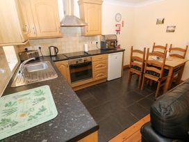 A kitchen with appliances and dining area at The Stall in Penuel near Llanmorlais