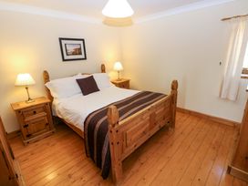 A bedroom with a bed and nightstands at The Stall in Penuel near Llanmorlais
