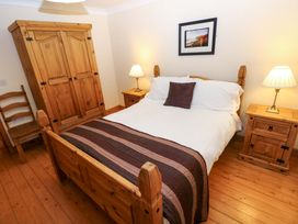 A bedroom with a bed and wooden furniture at The Stall in Penuel near Llanmorlais