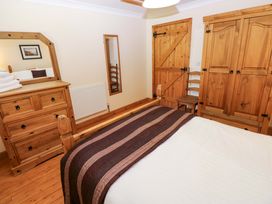 A bedroom with a bed, dresser, and wardrobe at The Stall in Penuel near Llanmorlais