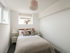 A bedroom with a bed and nightstand at Minerva in Trearddur Bay
