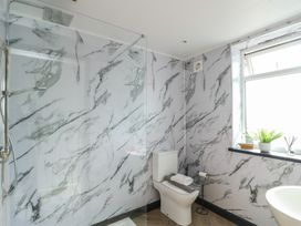 A bathroom with a shower, toilet, and sink at Minerva, Trearddur Bay