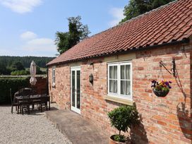 An outdoor patio with a table and chairs at Stable Cottage in Cawton near Hovingham