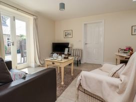 A living room with a television and tea set at Stable Cottage in Cawton near Hovingham
