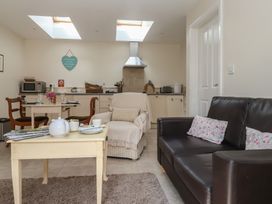 A kitchen with a table, chairs, and a sofa at Stable Cottage in Cawton near Hovingham
