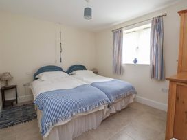 A bedroom with twin beds and a wardrobe at Stable Cottage Cawton near Hovingham