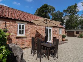 An outdoor area with a table and chairs at Stable Cottage in Cawton near Hovingham