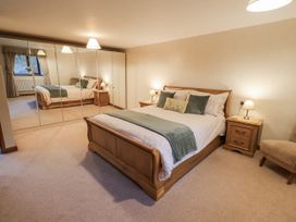 A bedroom with a bed and mirror at Christine's Stable in Shap near Maulds Meaburn