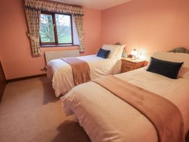 A bedroom with two beds and a bedside table at Christine's Stable in Shap near Maulds Meaburn