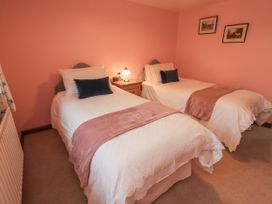 A bedroom with two single beds and a bedside table at Christine's Stable Shap near Maulds Meaburn
