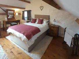 A bedroom with a bed and dresser at Y Bwthyn in Ysbyty Ifan