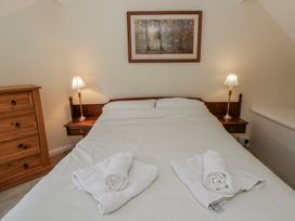 A bedroom with a bed and a dresser at Riverside Cottage Llanwrthwl near Rhayader