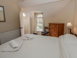 A bedroom with a bed and dresser at Riverside Cottage in Llanwrthwl near Rhayader