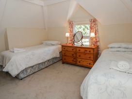 A bedroom with two single beds and a dresser at Riverside Cottage Llanwrthwl near Rhayader