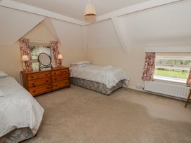 A bedroom with two beds and a dresser at Riverside Cottage Llanwrthwl near Rhayader
