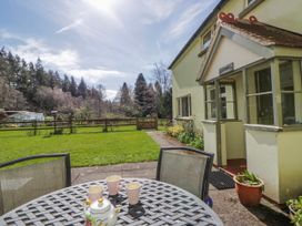 A garden with a table and teapot at Gardener's Cottage in Llanwrthwl near Rhayader