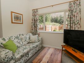 A living room with a sofa and television at Gardener's Cottage, Llanwrthwl near Rhayader