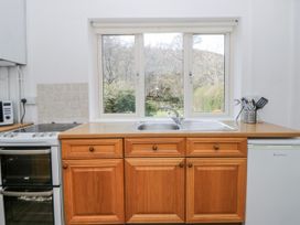 A kitchen with a sink and oven at Gardener's Cottage near Llanwrthwl