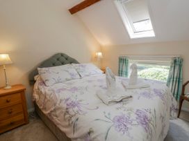 A bedroom with a bed and lamps at Gardener's Cottage in Llanwrthwl near Rhayader