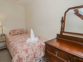 A bedroom with a bed and dresser at Gardener's Cottage in Llanwrthwl near Rhayader