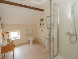 A bathroom with a shower and toilet at Gardener's Cottage in Llanwrthwl near Rhayader