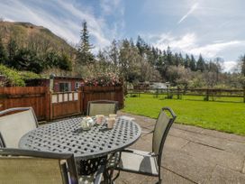 A garden with a table and chairs at Gardener's Cottage Llanwrthwl near Rhayader