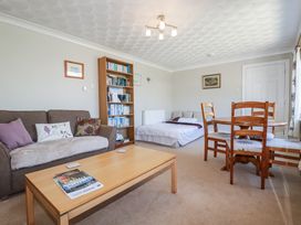 A living room with a sofa, coffee table, and dining table at Jenny Wren in Tywardreath near Fowey